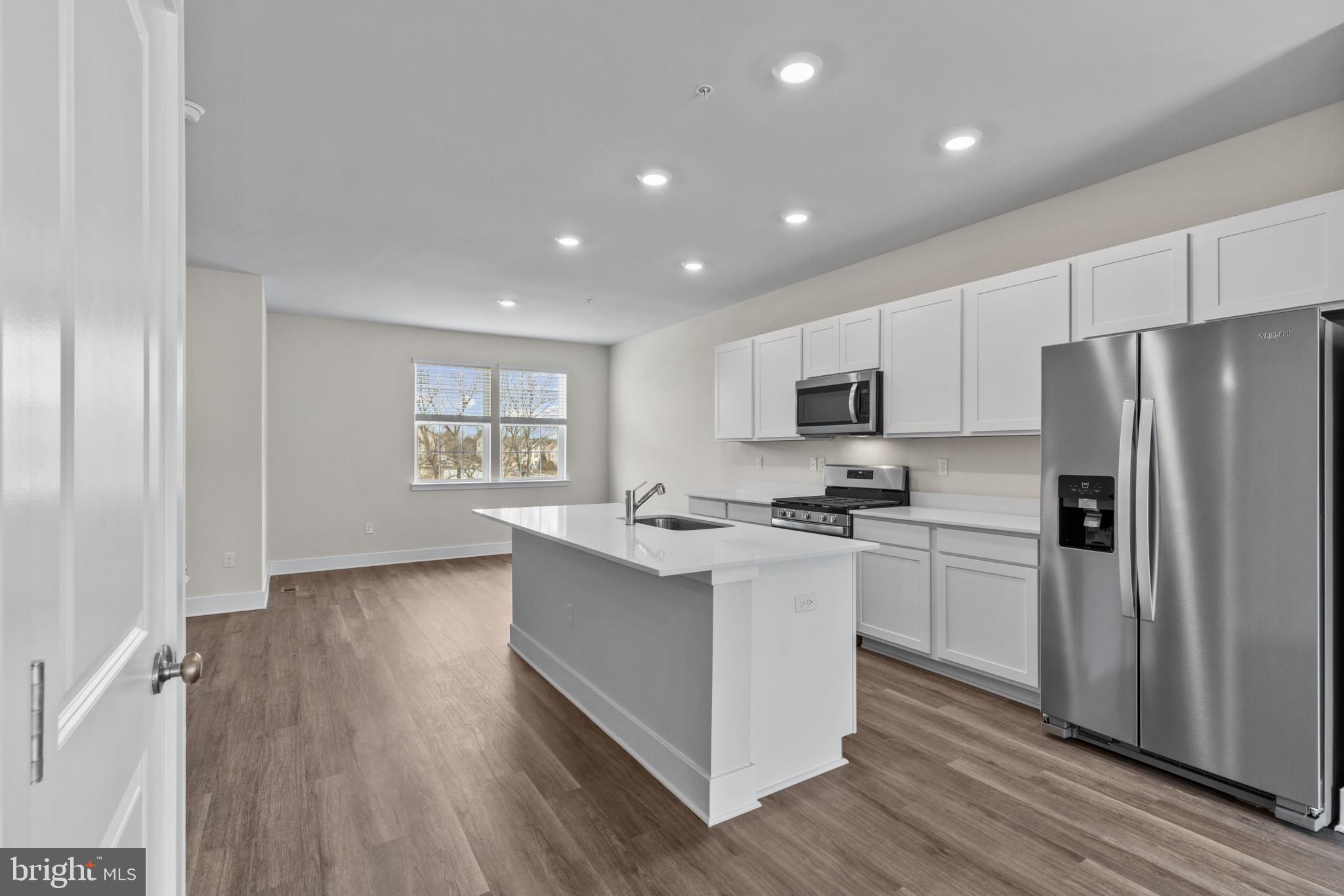 330 Hackley Drive Joppa, MD 21085 - Photo 11 of 32 a kitchen with stainless steel appliances granite countertop a stove a sink dishwasher a refrigerator and a microwave oven with wooden floor