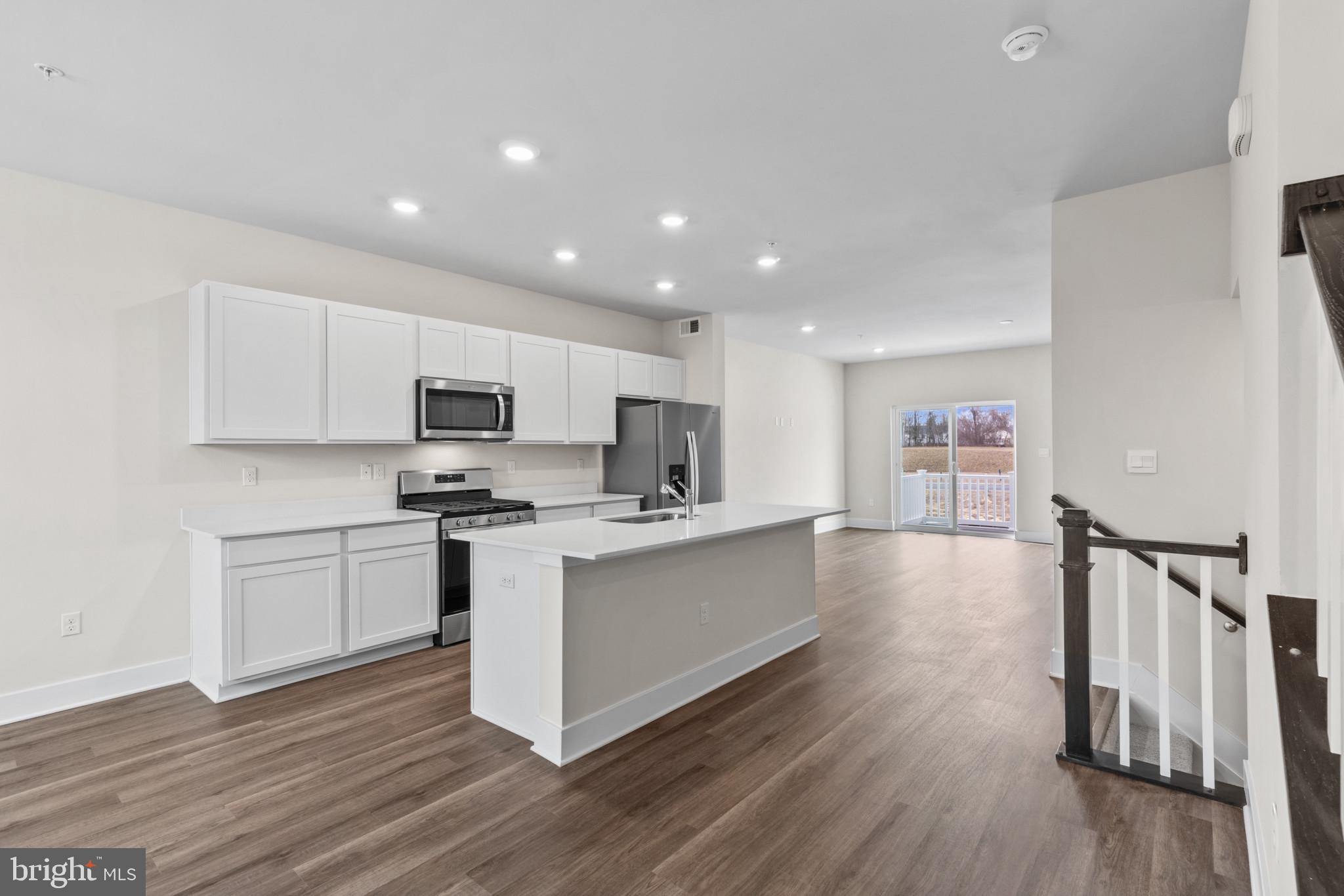 330 Hackley Drive Joppa, MD 21085 - Photo 9 of 32 a kitchen with stainless steel appliances a stove top oven a sink a refrigerator and white cabinets with wooden floor