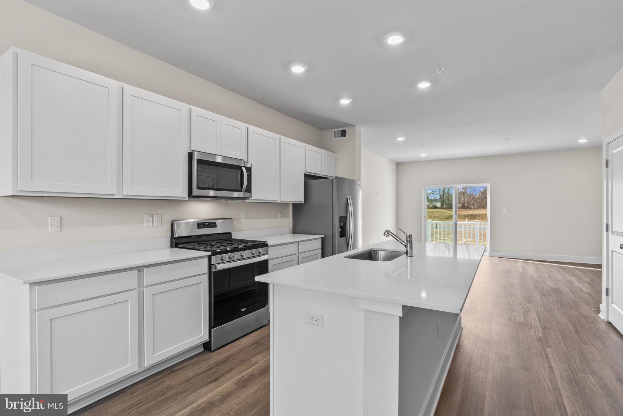 330 Hackley Drive Joppa, MD 21085 - Photo 10 of 32 a kitchen with stainless steel appliances granite countertop a stove top oven a sink dishwasher and a refrigerator with wooden floor