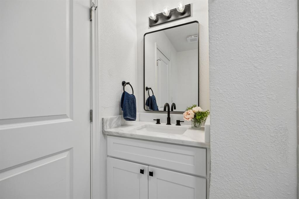 806 North Ruddell Street Denton, TX 76209 - Photo 24 of 26 a bathroom with a sink vanity and a mirror