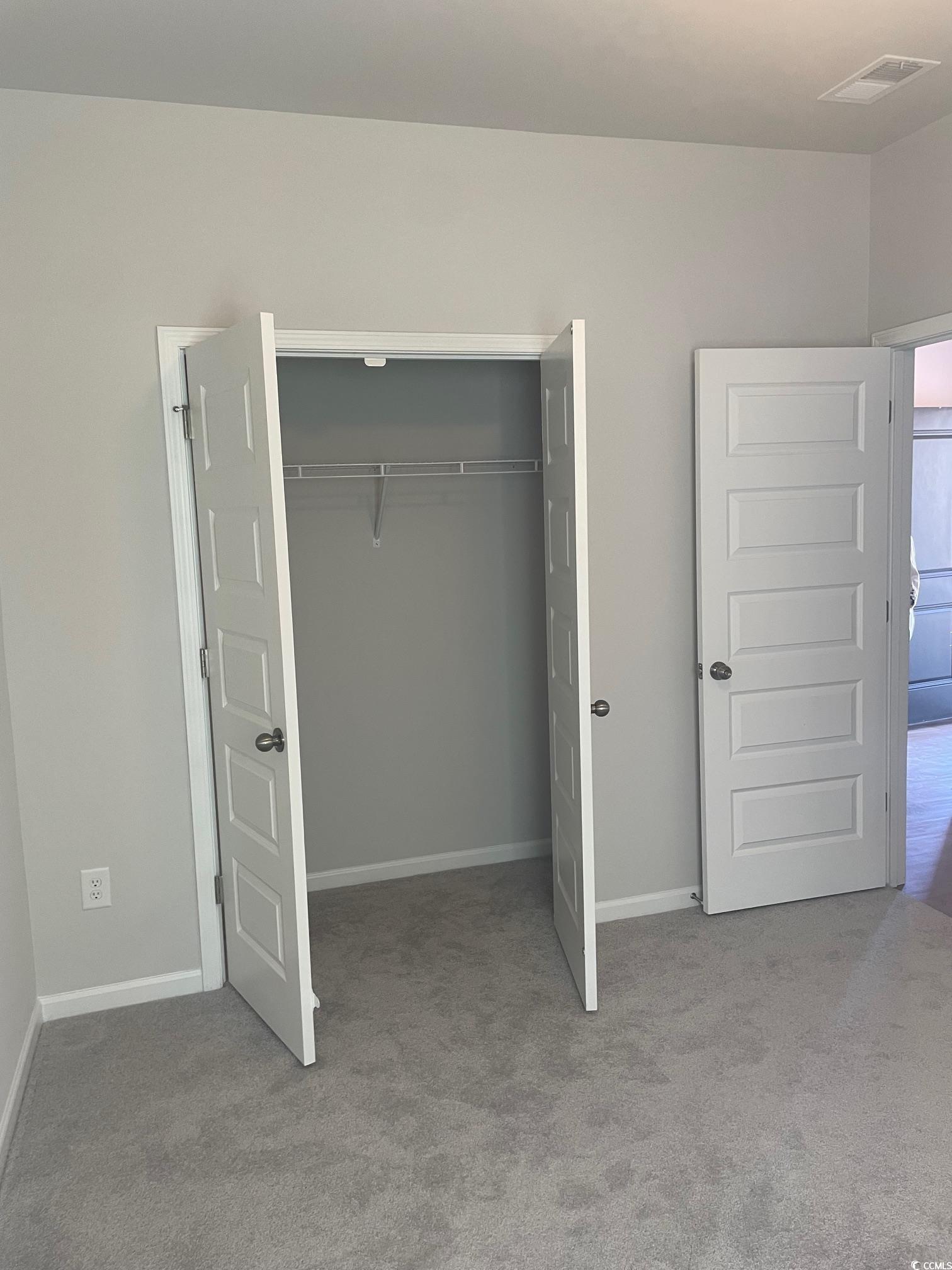 61 S Reindeer Road South Surfside Beach, SC 29575 - Photo 6 of 10 Unfurnished bedroom featuring light colored carpet and a closet