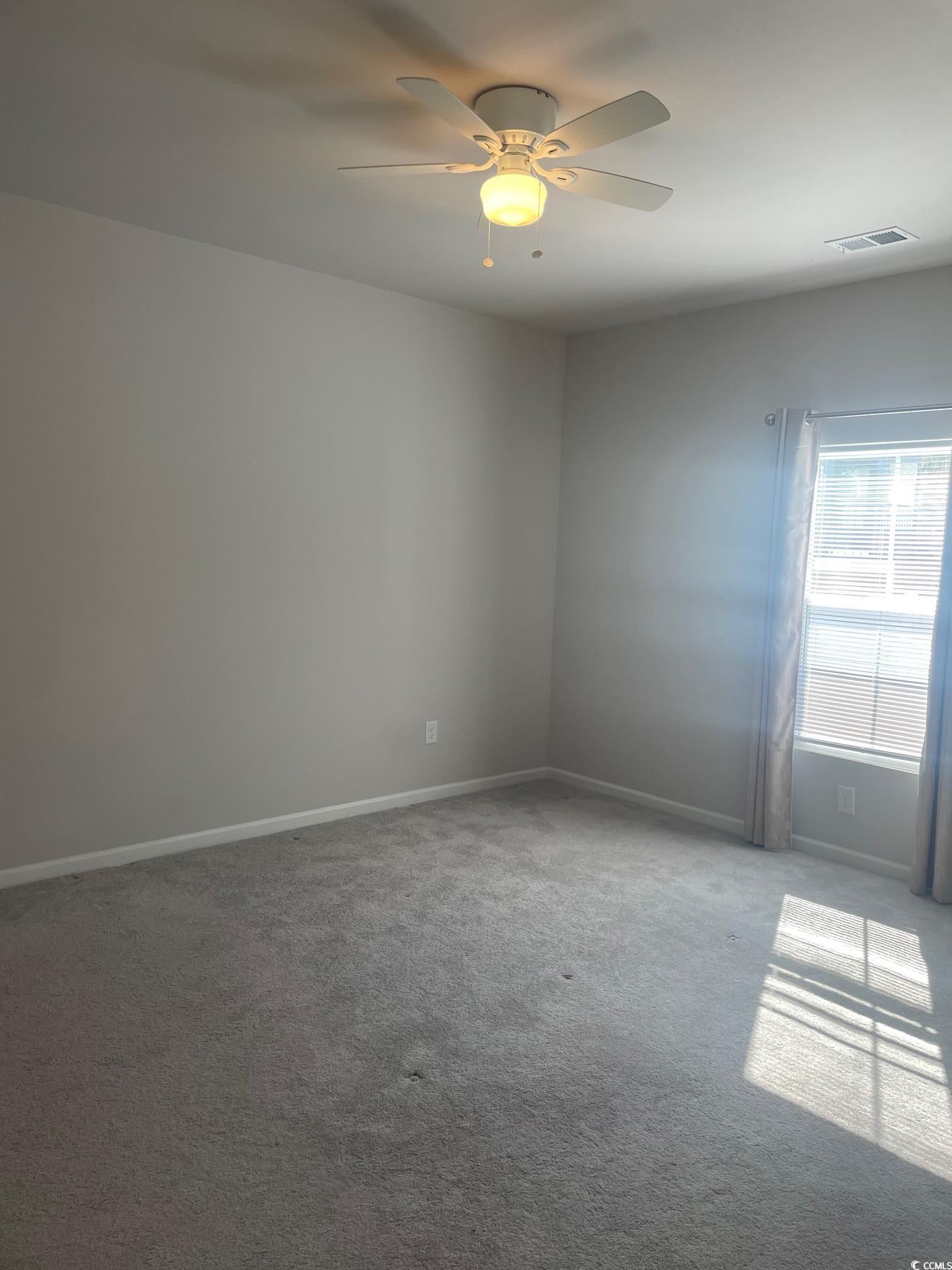 61 S Reindeer Road South Surfside Beach, SC 29575 - Photo 8 of 10 Empty room with light colored carpet and ceiling fan