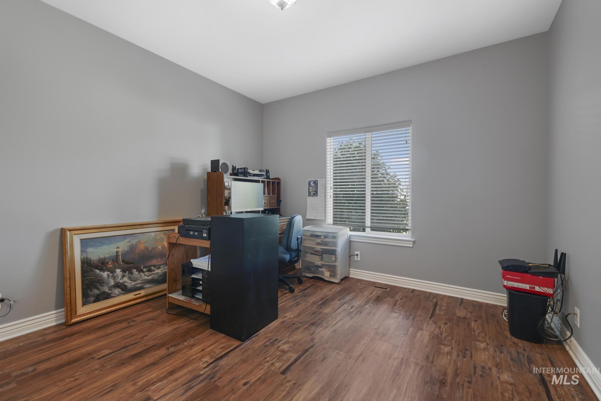 467 Wildrose Loop Twin Falls, ID 83301 - Photo 21 of 46 Spacious room featuring wood-finish flooring, light gray walls, white trim, and a window with blinds