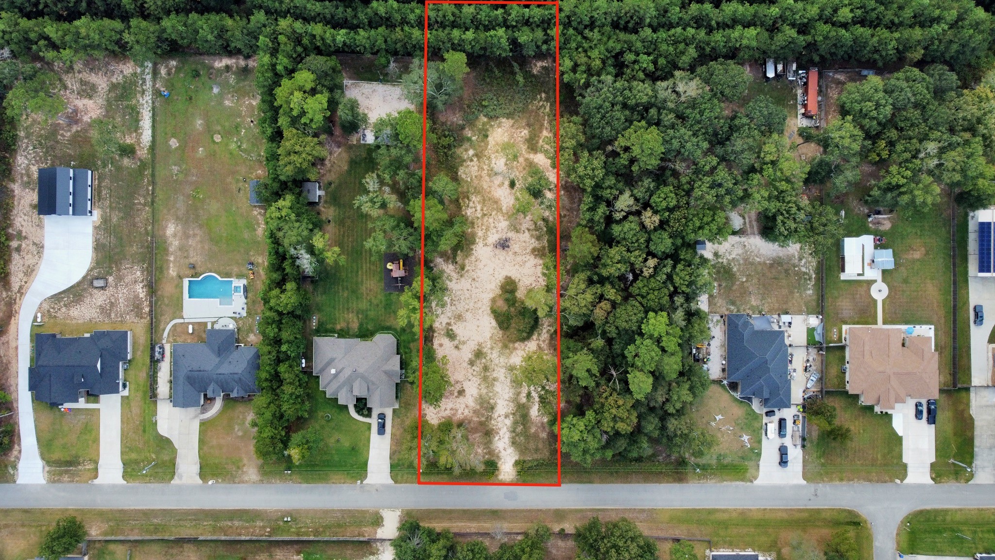 an aerial view of residential houses with outdoor space and lake view