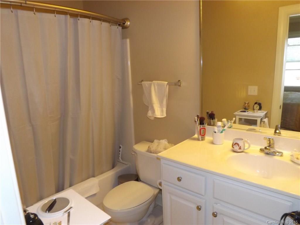 5601 Fairview Road, Unit 9 Charlotte, NC 28209 - Photo 10 of 13 a bathroom with a sink a toilet and shower curtain