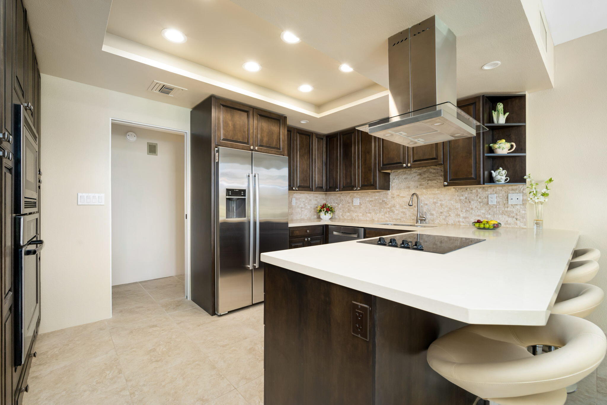 910 Island Drive, Unit 116 Rancho Mirage, CA 92270 - Photo 12 of 39 a kitchen with stainless steel appliances a sink a refrigerator and a stove top oven with wooden floor