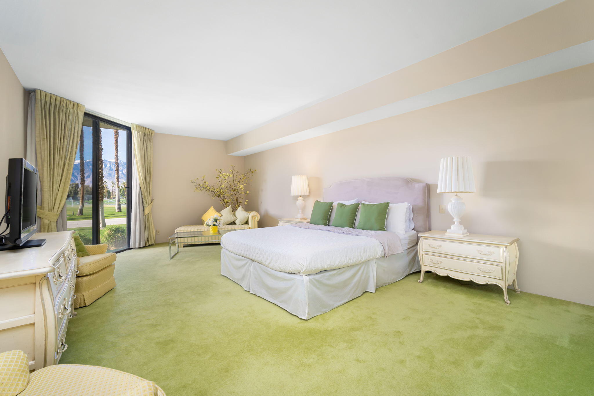 910 Island Drive, Unit 116 Rancho Mirage, CA 92270 - Photo 26 of 39 a spacious bedroom with a bed and a flat screen tv