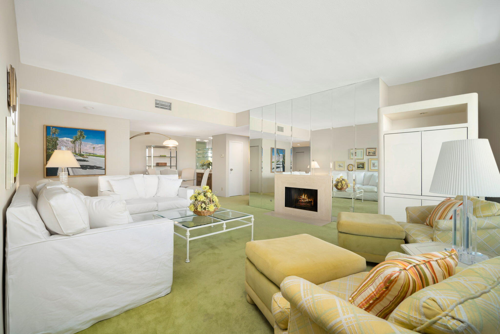 910 Island Drive, Unit 116 Rancho Mirage, CA 92270 - Photo 9 of 39 a living room with furniture white walls and a fireplace
