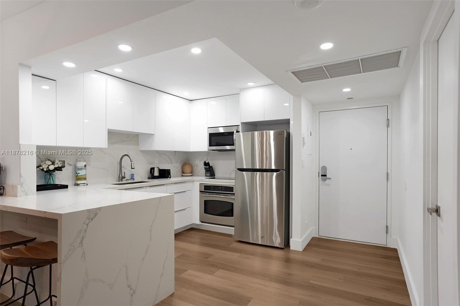 a kitchen with white cabinets and stainless steel appliances