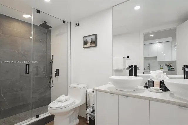 a bathroom with a toilet a sink and shower