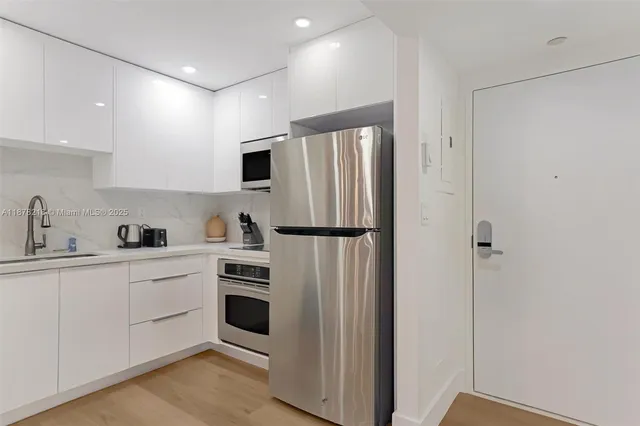 a kitchen with stainless steel appliances a refrigerator sink and cabinets