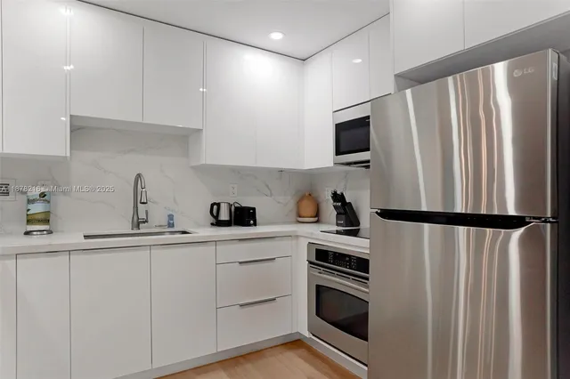a kitchen with a refrigerator sink and cabinets