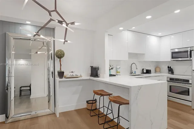 a kitchen with white cabinets and stainless steel appliances