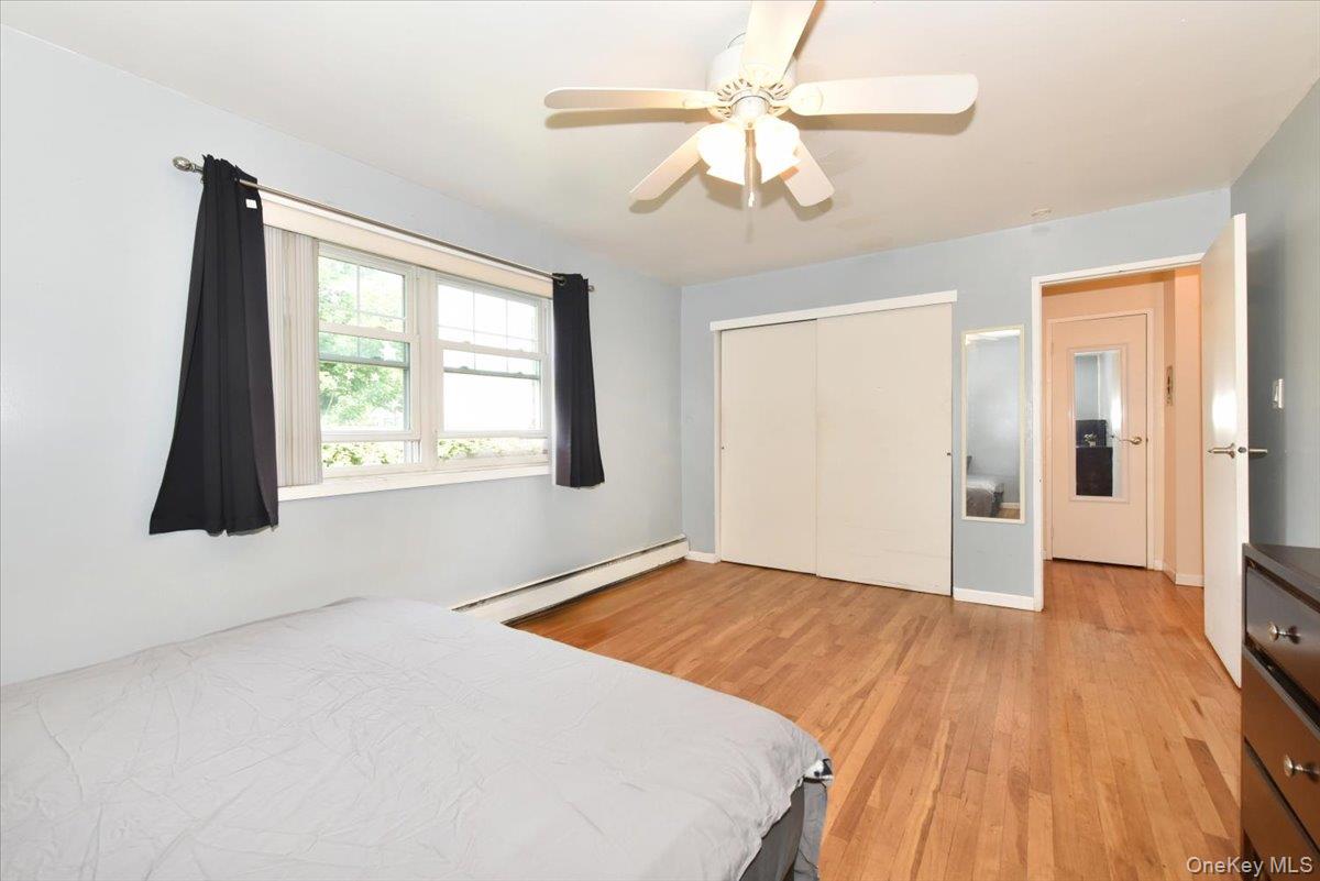 295 Merrick Road, Unit 4A Amityville, NY 11701 - Photo 12 of 16 a view of an empty room with a window and wooden floor