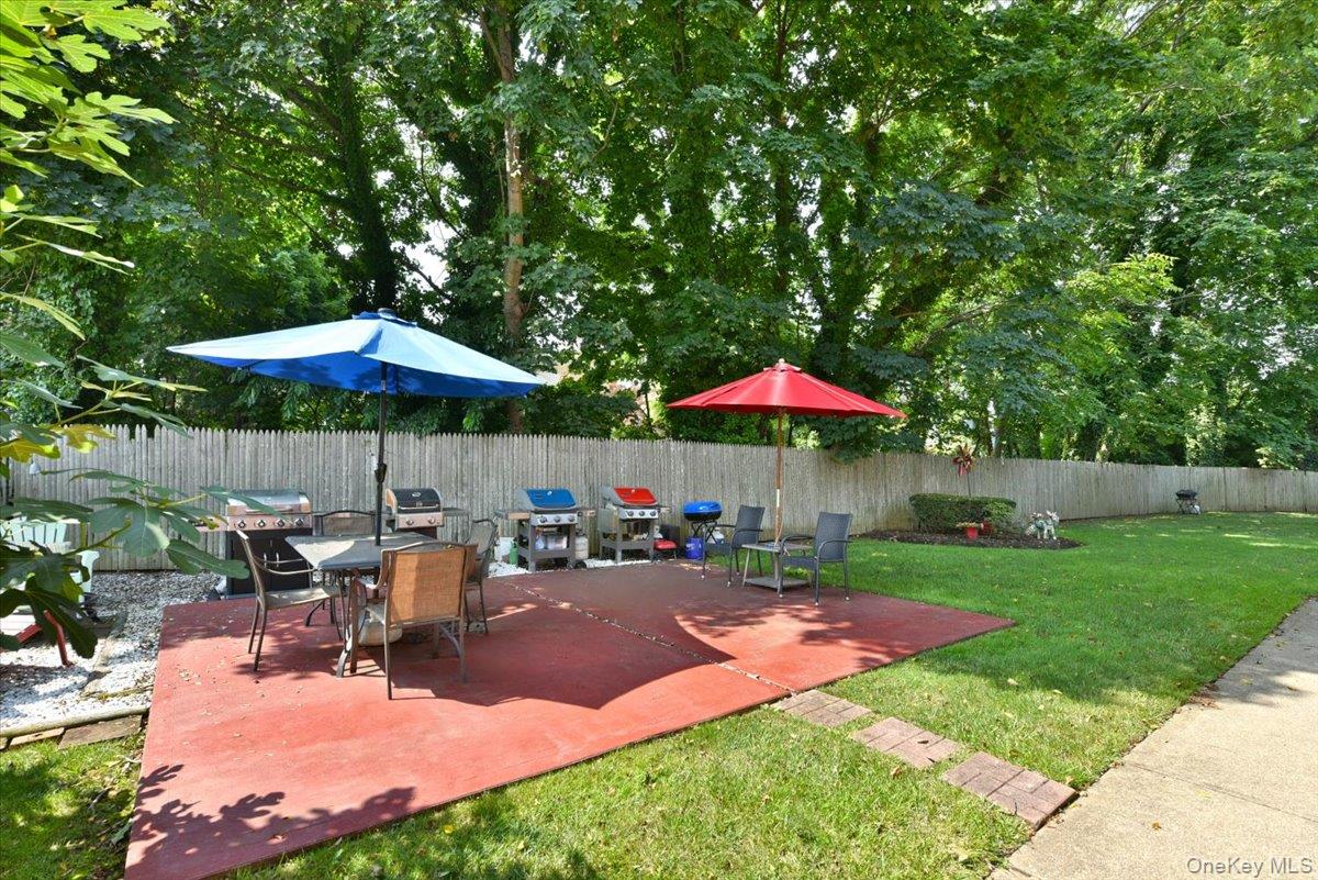 295 Merrick Road, Unit 4A Amityville, NY 11701 - Photo 14 of 16 a view of a backyard with chairs under an umbrella