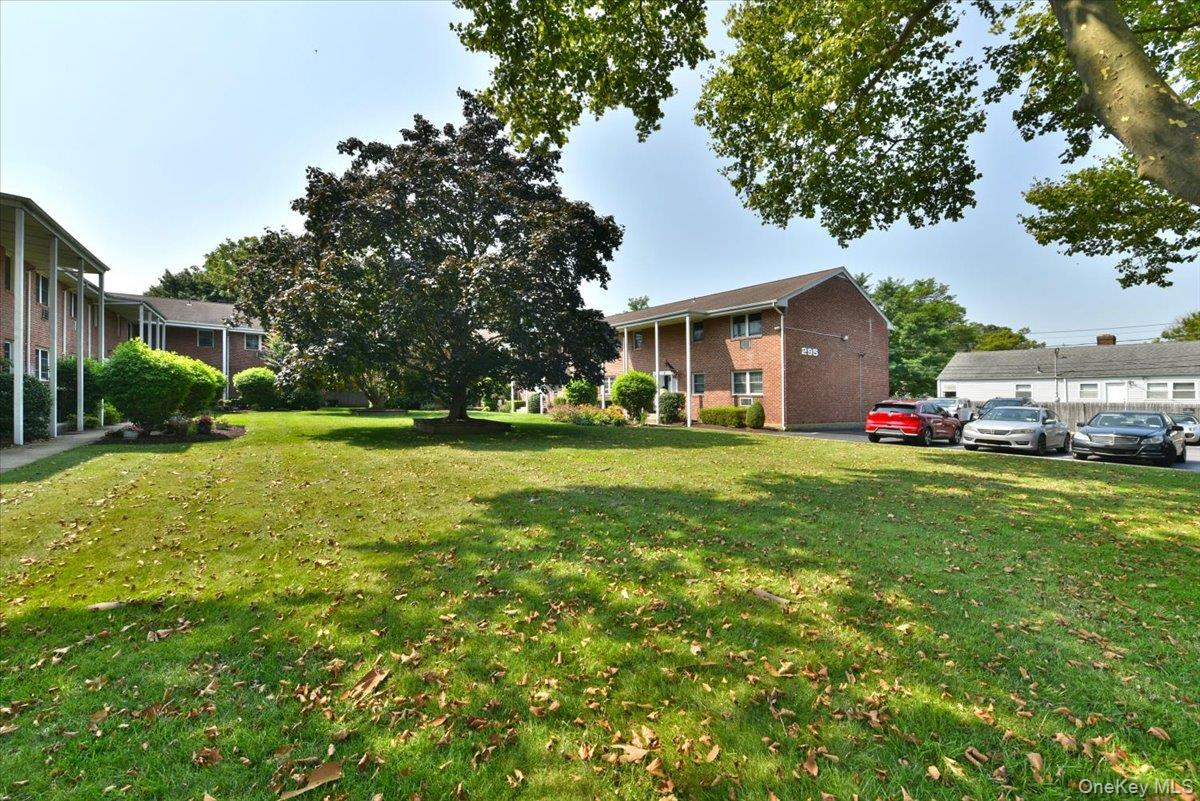 295 Merrick Road, Unit 4A Amityville, NY 11701 - Photo 2 of 16 a view of a house with a big yard and large trees