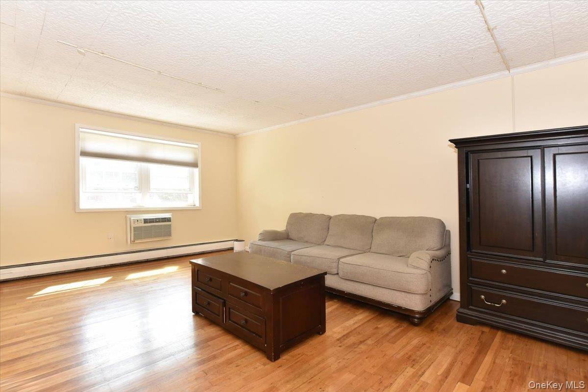 295 Merrick Road, Unit 4A Amityville, NY 11701 - Photo 4 of 16 a living room with furniture and a flat screen tv