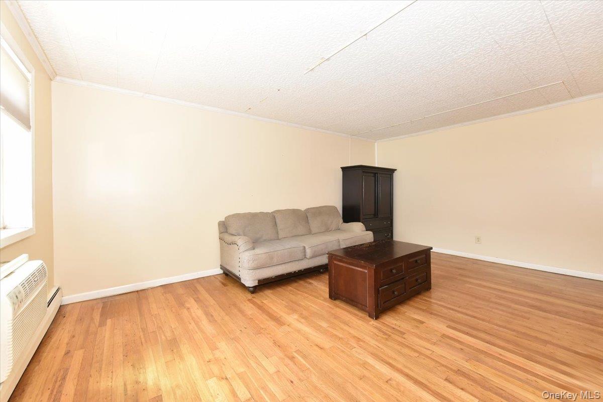 295 Merrick Road, Unit 4A Amityville, NY 11701 - Photo 5 of 16 a living room with furniture and a wooden floor