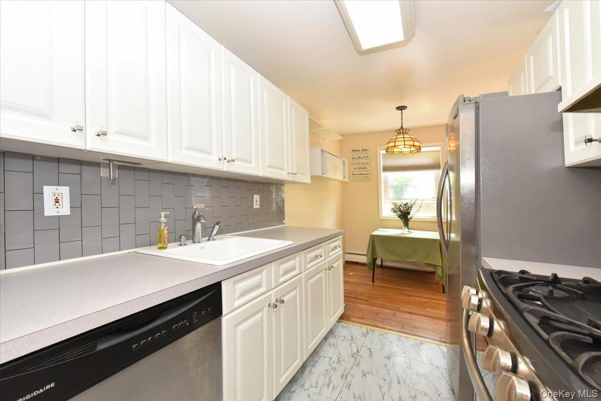 295 Merrick Road, Unit 4A Amityville, NY 11701 - Photo 8 of 16 a kitchen with a sink stove and cabinets
