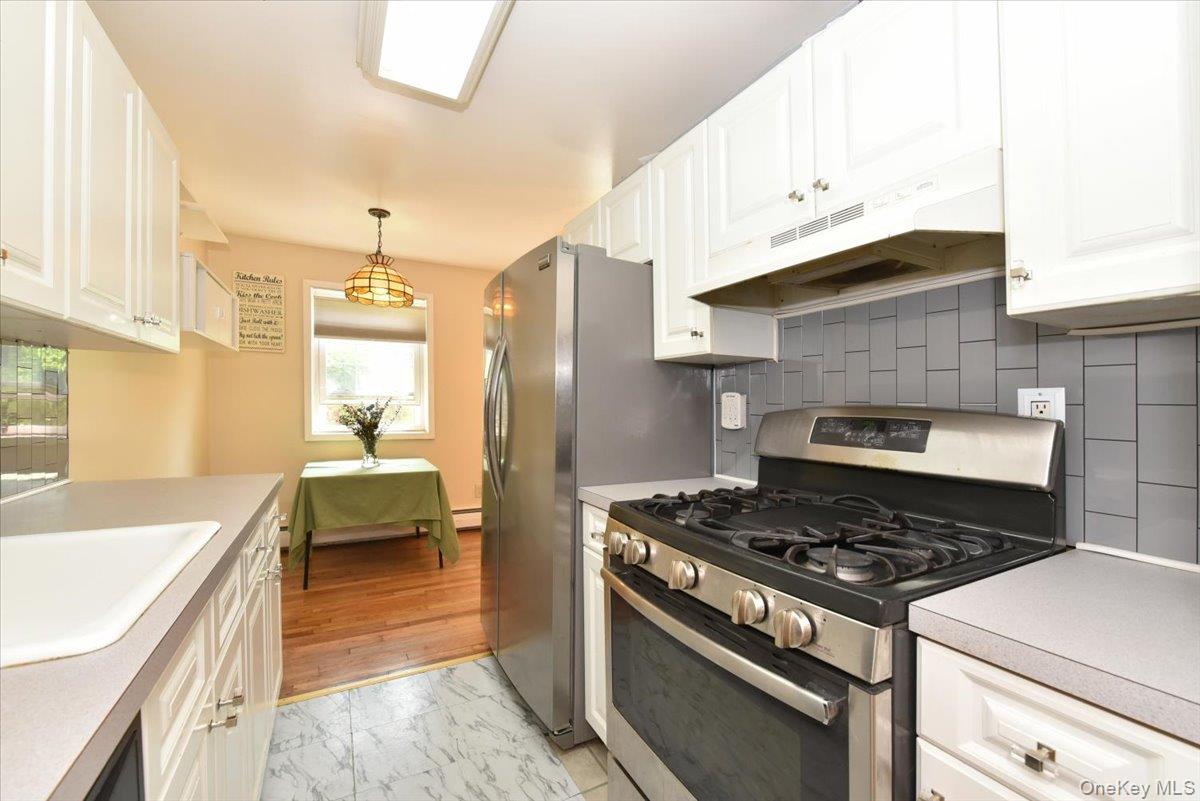 295 Merrick Road, Unit 4A Amityville, NY 11701 - Photo 9 of 16 a kitchen with a stove and a sink