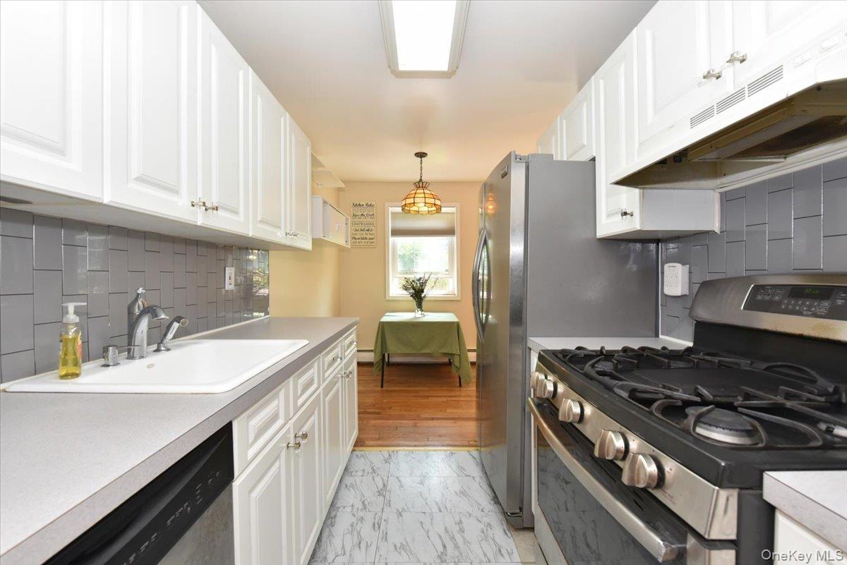 295 Merrick Road, Unit 4A Amityville, NY 11701 - Photo 10 of 16 a kitchen with a stove and a sink