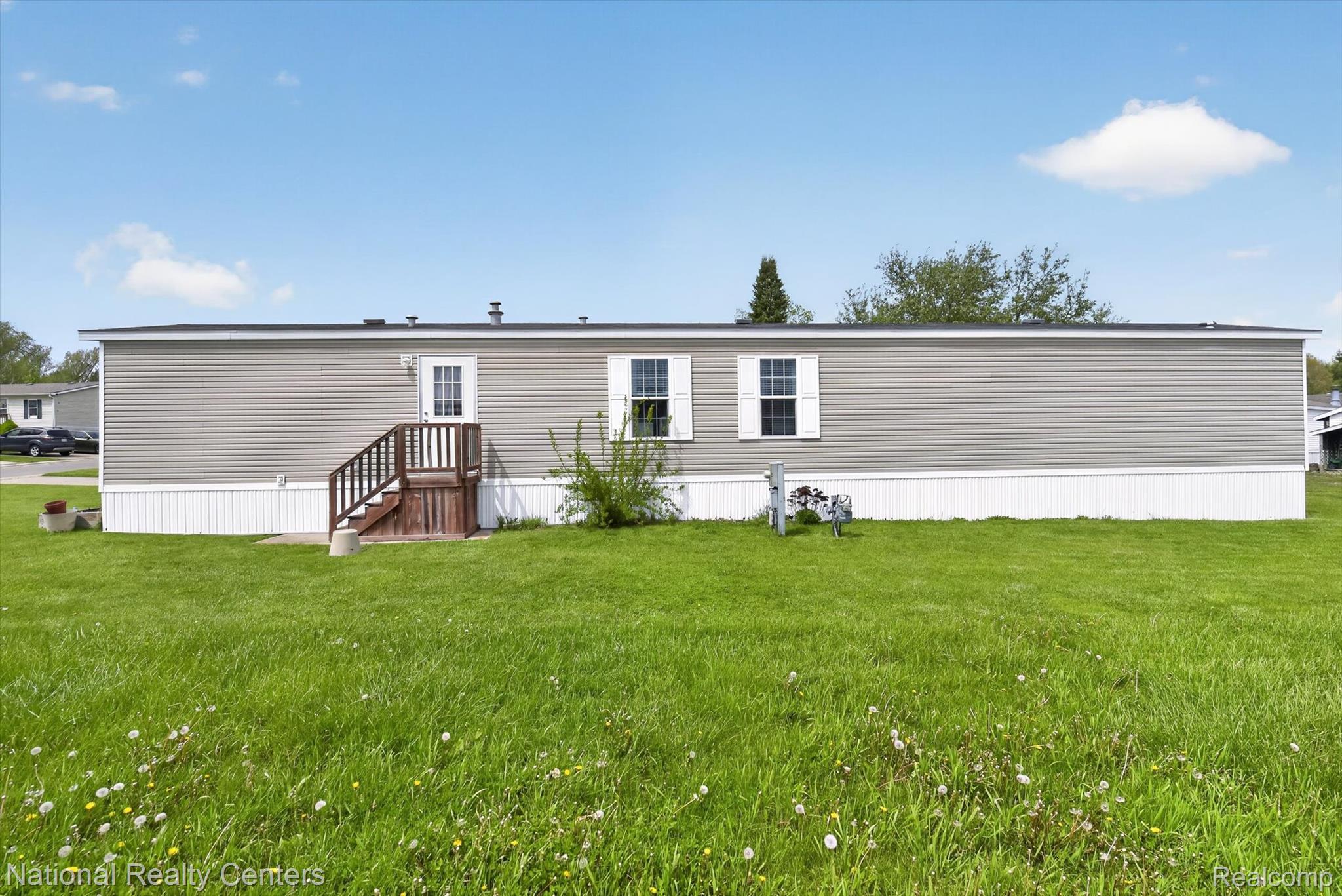 2735 South Wagner Road, Unit 103 Ann Arbor, MI 48103 - Photo 17 of 20 Rear view of property featuring a lawn