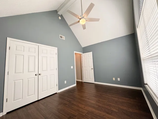 an empty room with wooden floor and windows