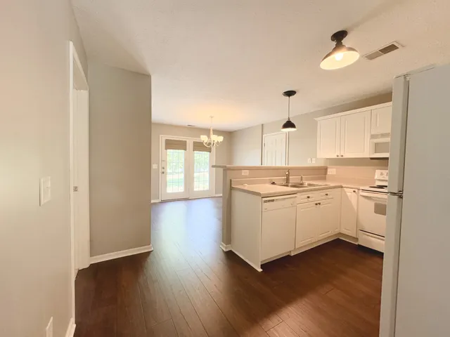 a kitchen with wooden floors and white appliances