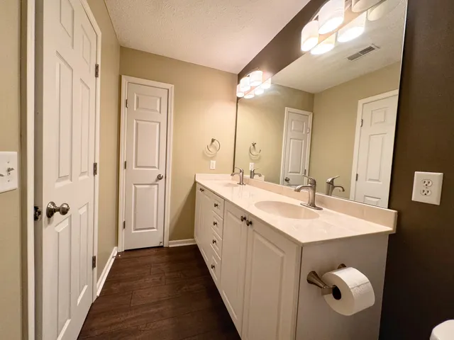 a spacious bathroom with a double vanity sink and mirror