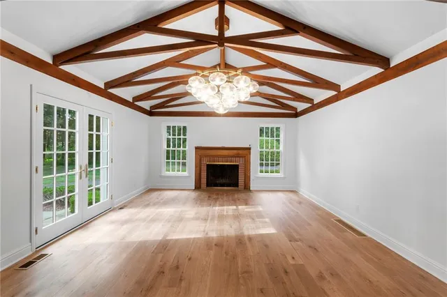 a view of an empty room with a fireplace and a window