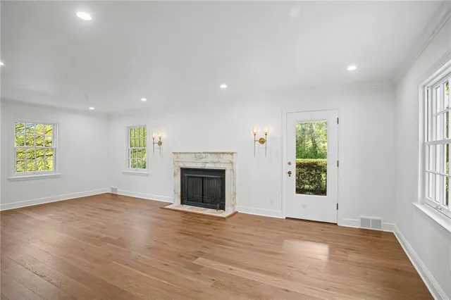 an empty room with windows and fireplace