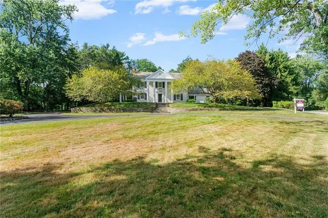a view of a swimming pool with lawn chairs and plants