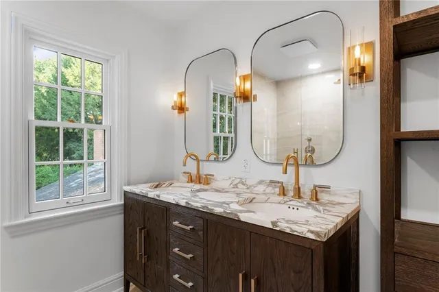 a bathroom with a granite countertop sink and a mirror