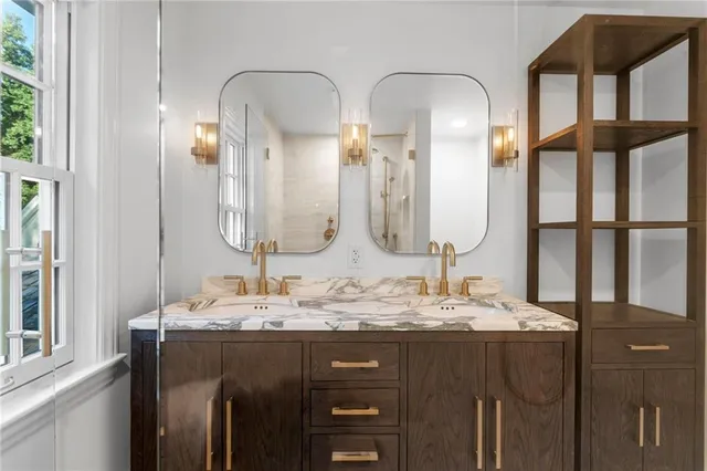 a bathroom with double vanity sinks and a mirror