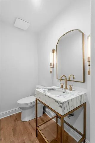 a bathroom with a toilet a sink and mirror