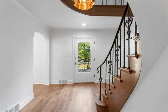 a view of staircase with wooden floor and white walls