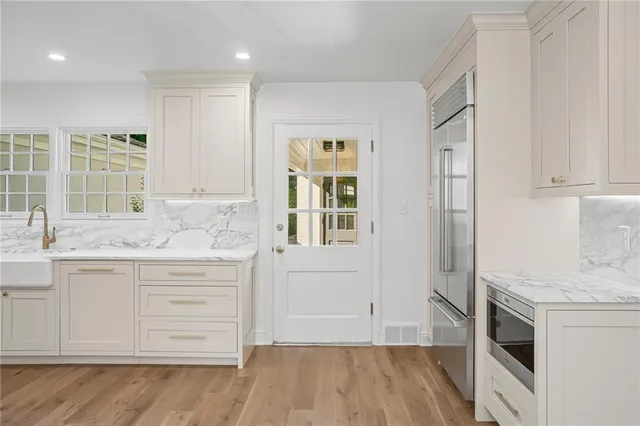 a kitchen with granite countertop white cabinets and white appliances