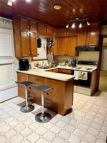 a bathroom with a sink and mirror with bathtub