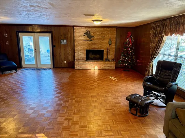 a living room with furniture a flat screen tv and a refrigerator