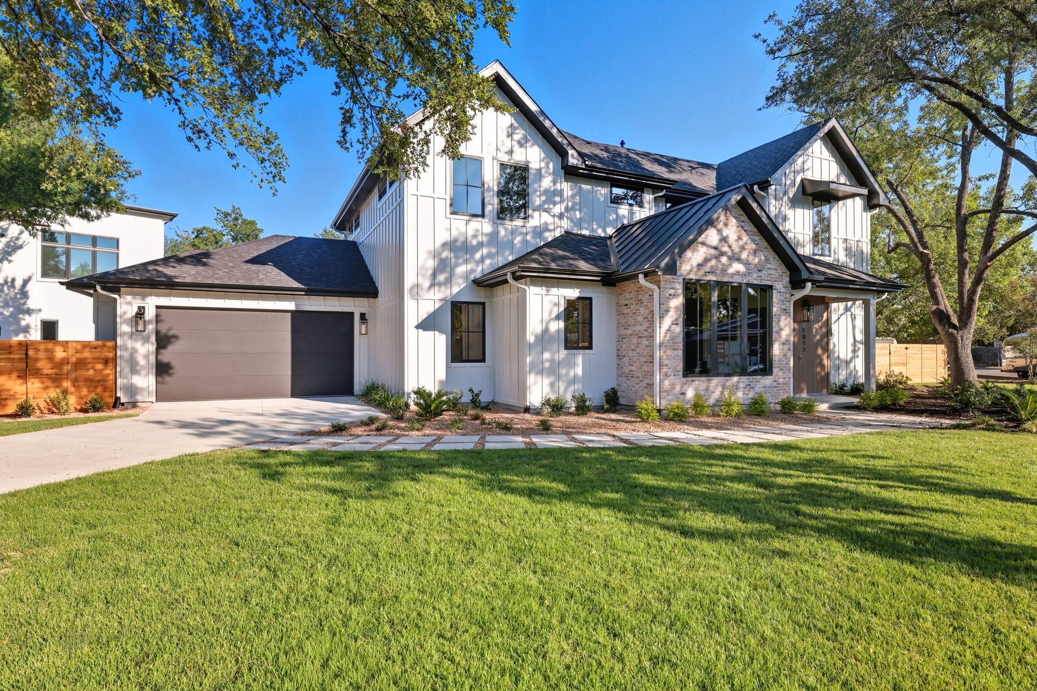 5012 Highland Court Austin, TX 78731 - Photo 3 of 32 Modern inspired farmhouse with concrete driveway, a standing seam roof, an attached garage, a shingled roof, and a metal roof