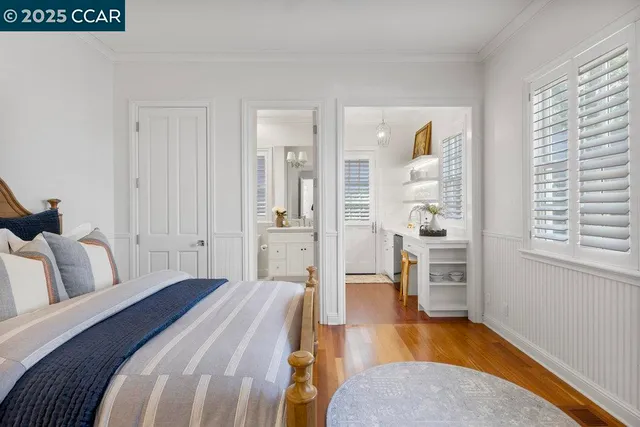 a spacious bedroom with a bed and wooden floor