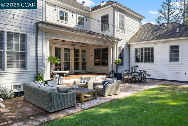 a view of a patio with couches table and chairs and potted plants