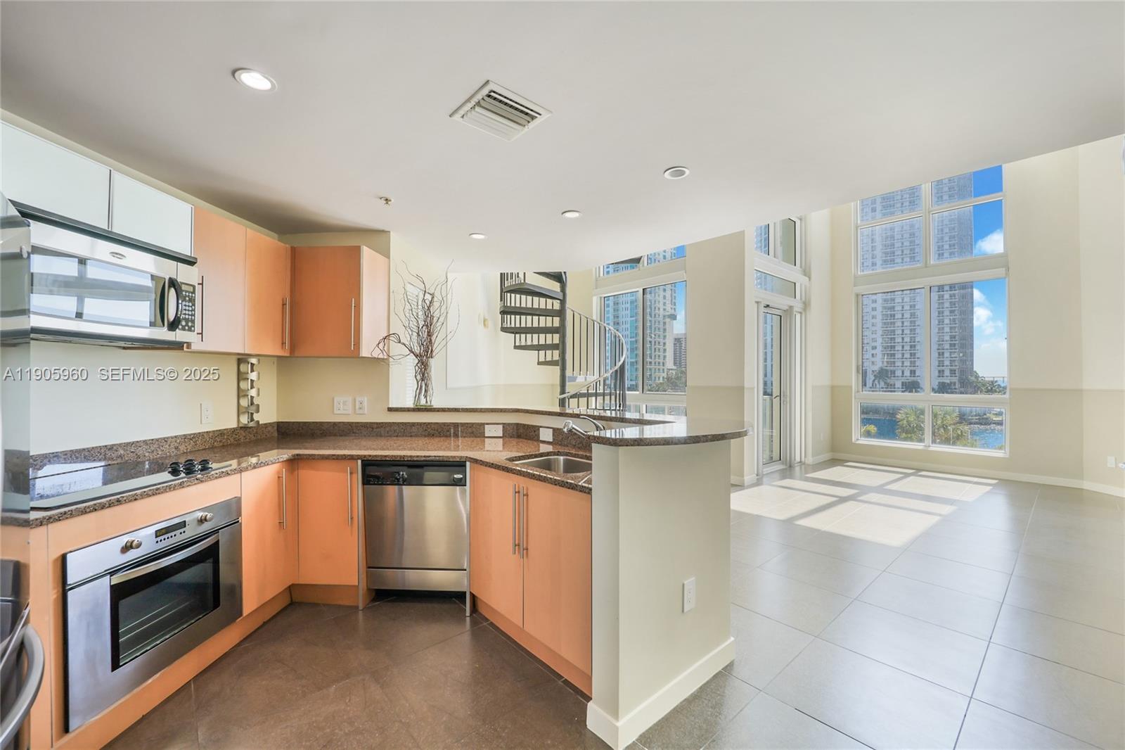 300 South Biscayne Boulevard, Unit L414 Miami, FL 33131 - Photo 2 of 21 a kitchen with stainless steel appliances granite countertop a stove a sink and a microwave