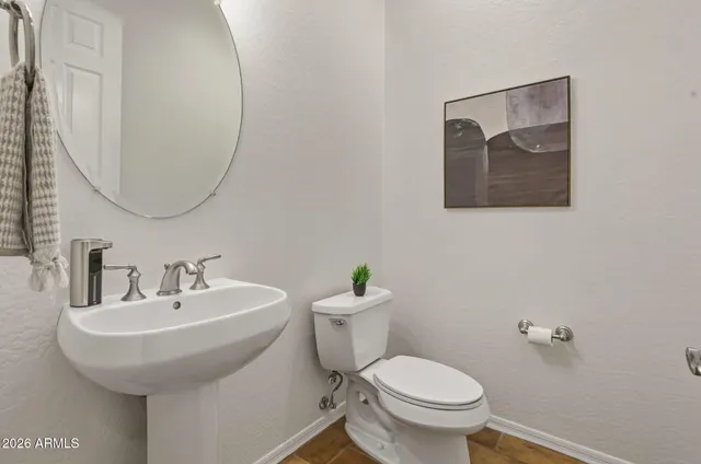 a bathroom with a toilet a sink and a mirror