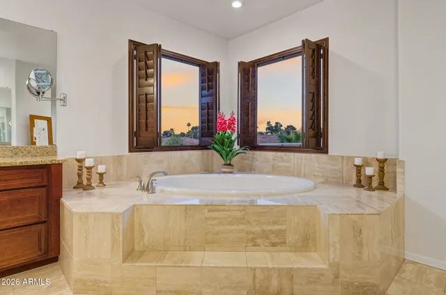 a bathroom with a granite countertop sink a mirror and a bathtub