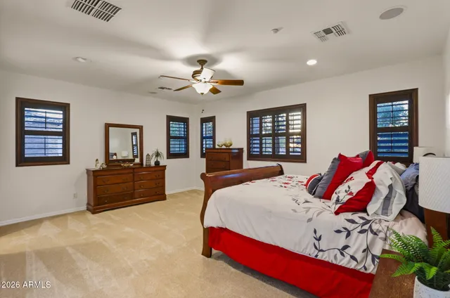 a bedroom with a large bed and a ceiling fan