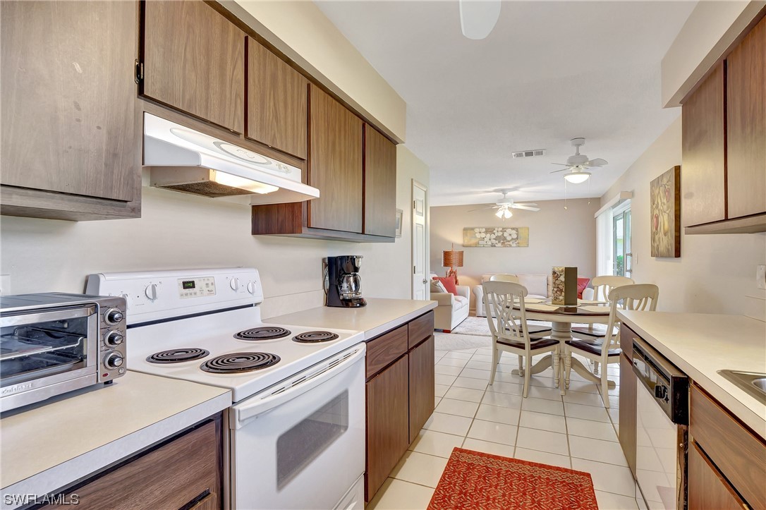 17508 Laurel Valley Road Fort Myers, FL 33967 - Photo 17 of 36 a kitchen with a stove and white cabinets