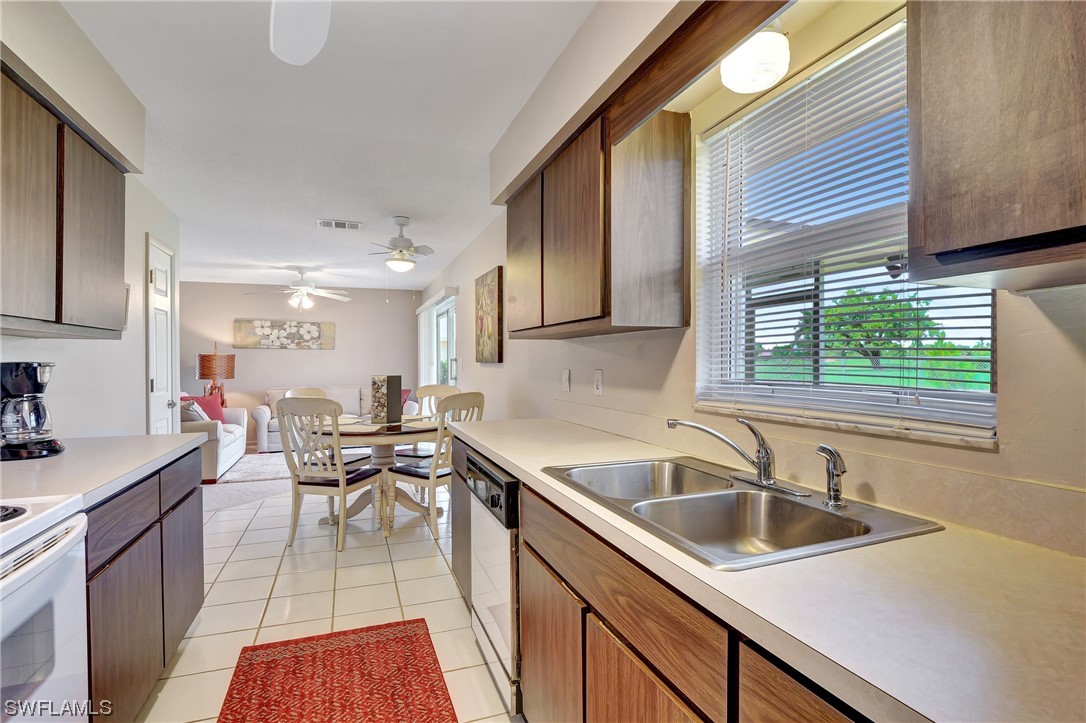 17508 Laurel Valley Road Fort Myers, FL 33967 - Photo 18 of 36 a kitchen with a sink a counter top space cabinets stainless steel appliances and a window