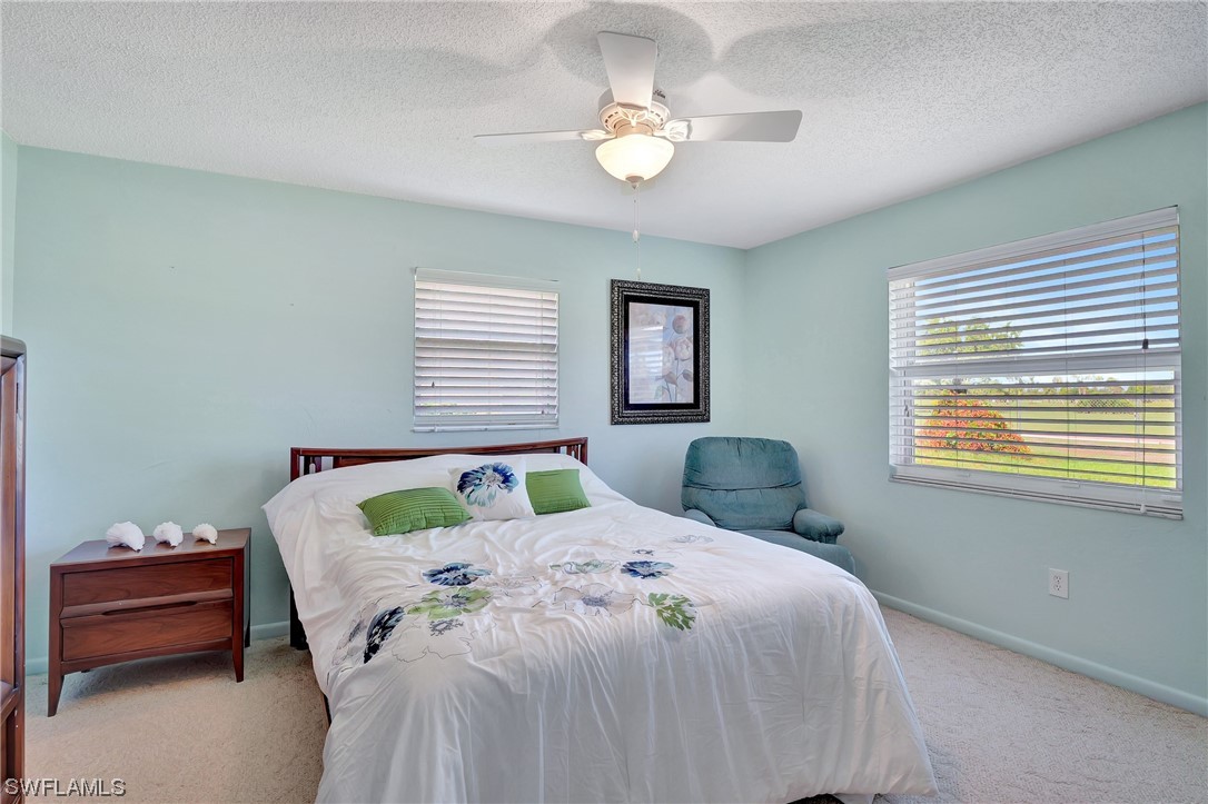 17508 Laurel Valley Road Fort Myers, FL 33967 - Photo 21 of 36 a bedroom with a bed and a chandelier