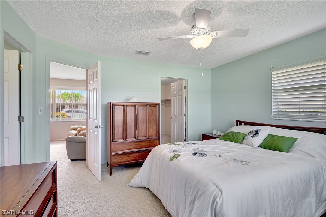 17508 Laurel Valley Road Fort Myers, FL 33967 - Photo 22 of 36 a bedroom with a bed and a chandelier